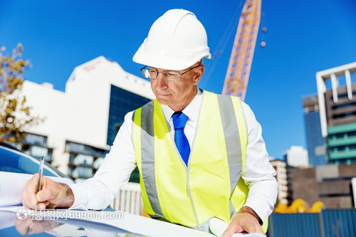 建筑工地的工程师建设者工程师建筑工人施工场景穿着带蓝图的安全背心